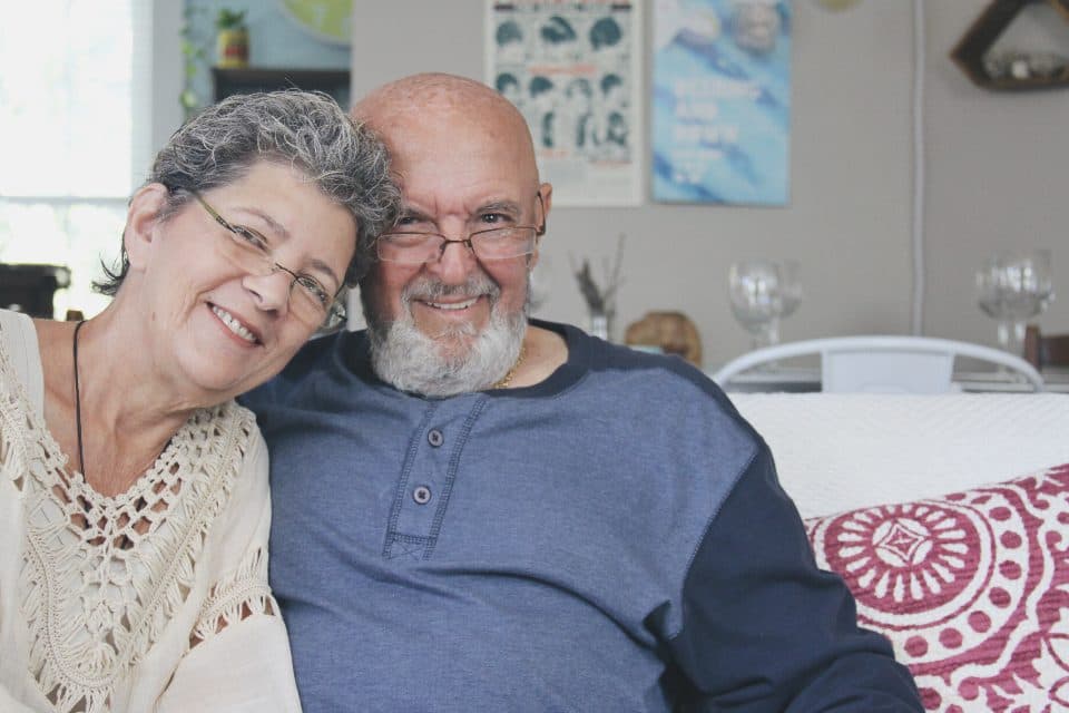 An older couple sitting together at home, smiling